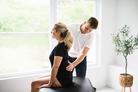 A male physio therapist and woman helping patient