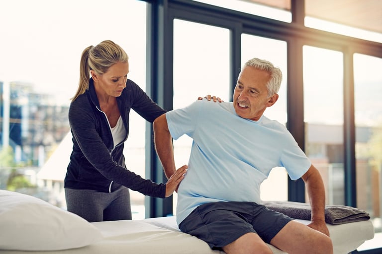 Shot of a physiotherapist examining a senior patient with back pain in her office